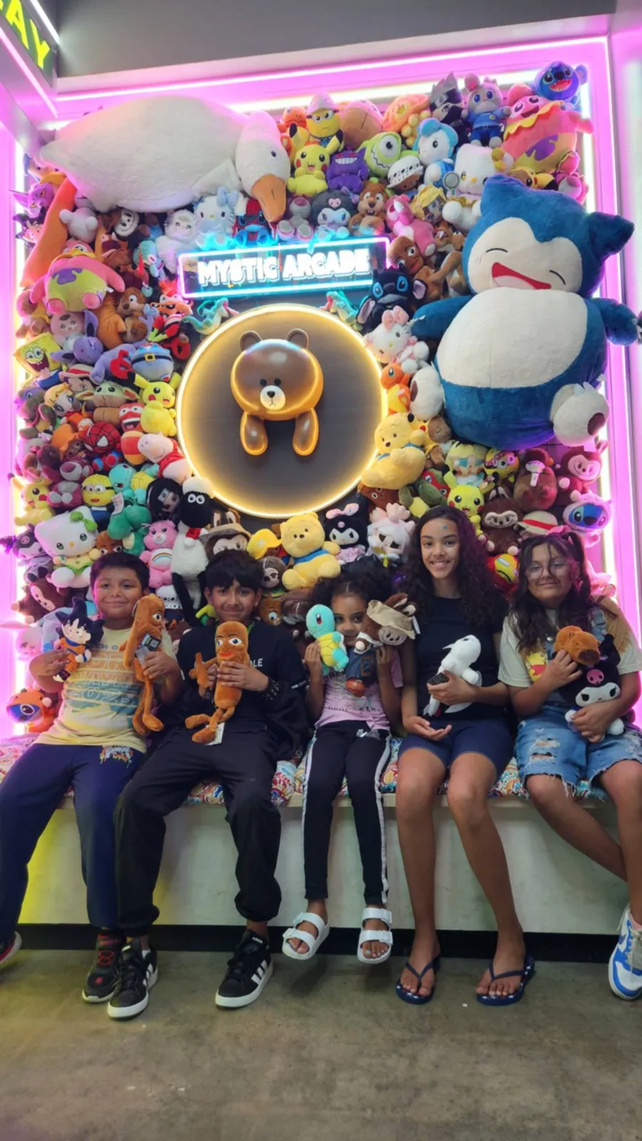 Group of friends at the Mystic Arcade plush wall
